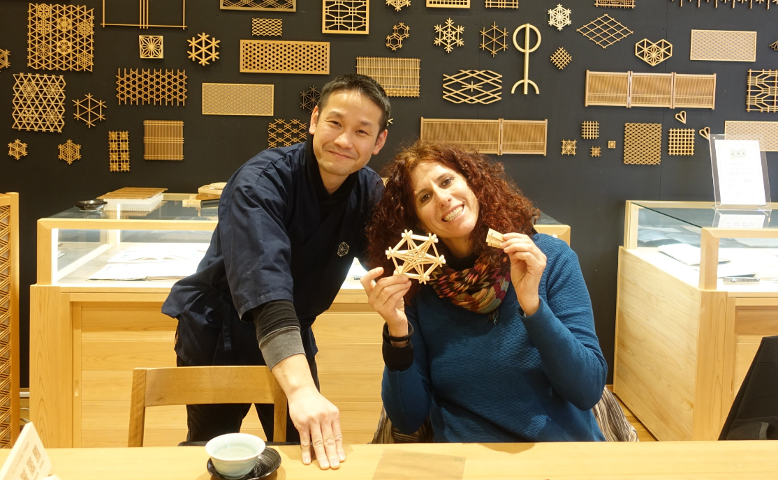 Participants and staff enjoying a kumiko workshop while holding completed pieces