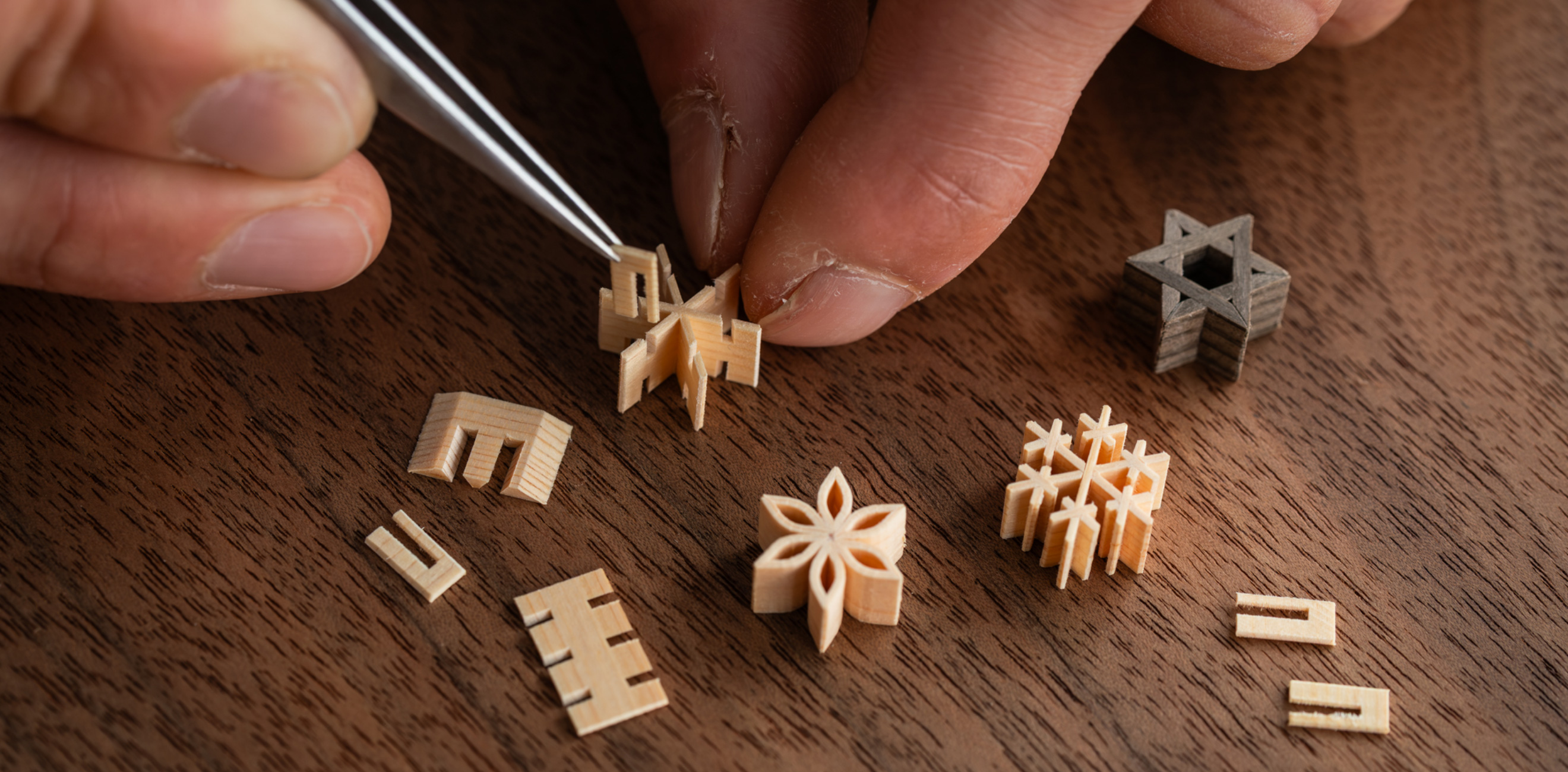 Close-up of a kumiko craftsman assembling a miniature kumiko piece with delicate handwork