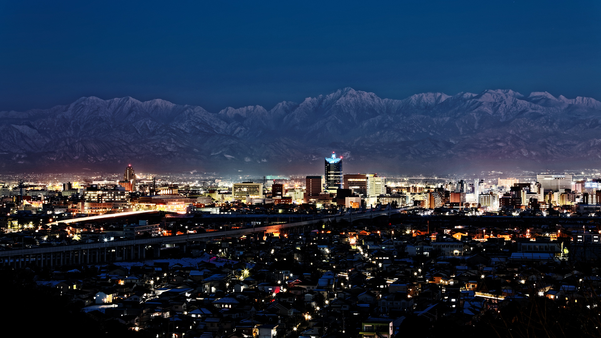 A panoramic night view of Toyama Prefecture with the Tateyama Mountain Range beyond